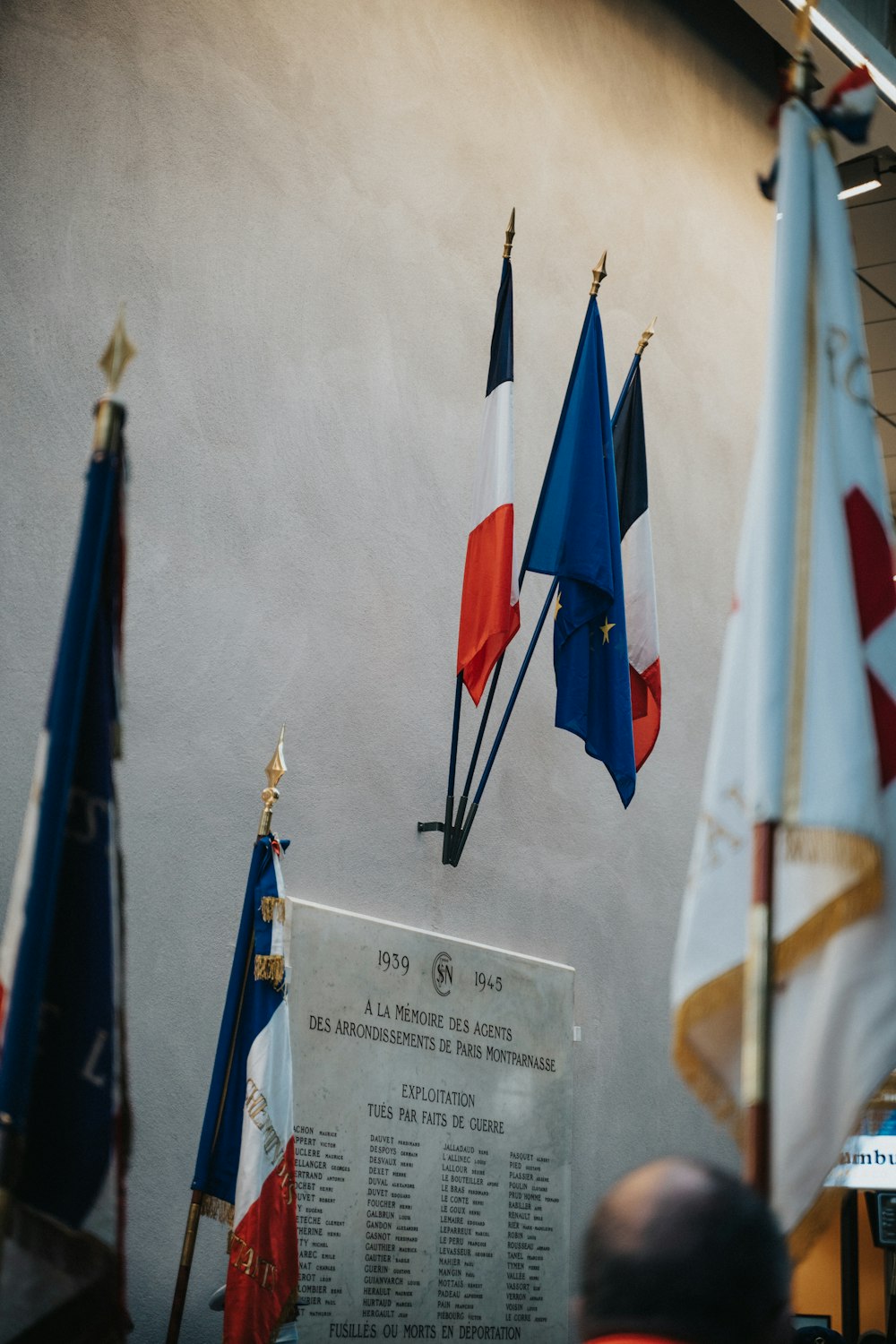 a group of flags hanging from the side of a wall