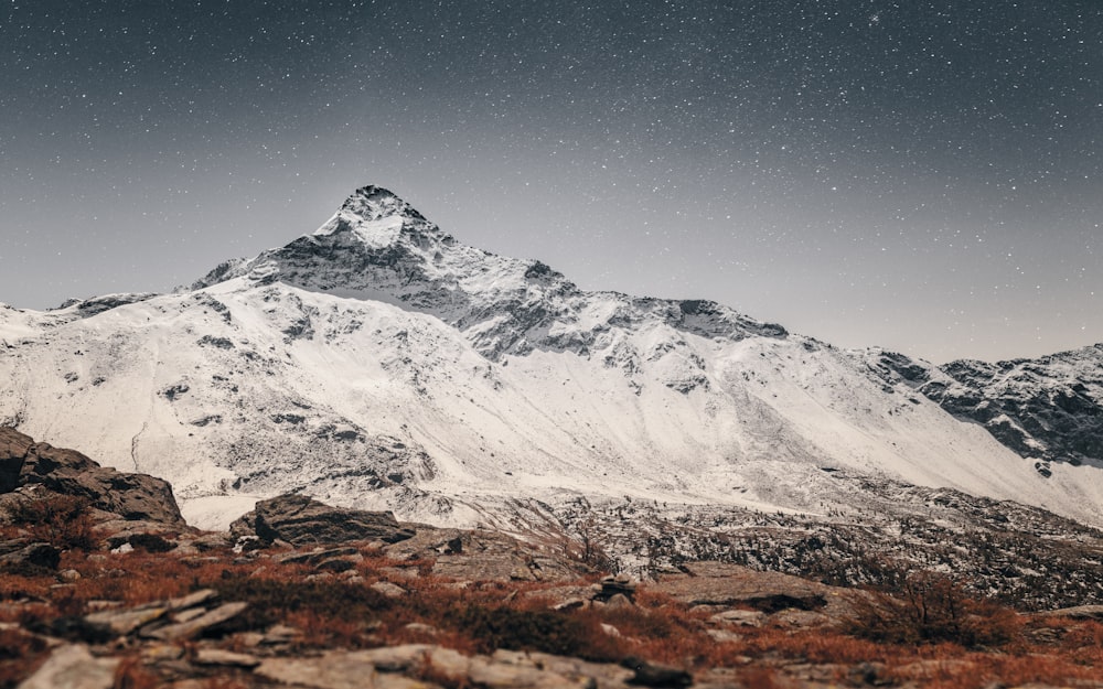 a snow covered mountain under a star filled sky