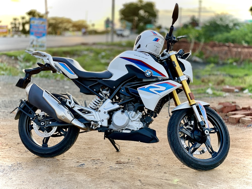 a white and blue motorcycle parked on a dirt road