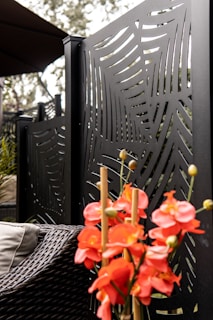 Outdoor patio featuring a vibrant red powder-coated metal flower arrangement, catching the afternoon sun.