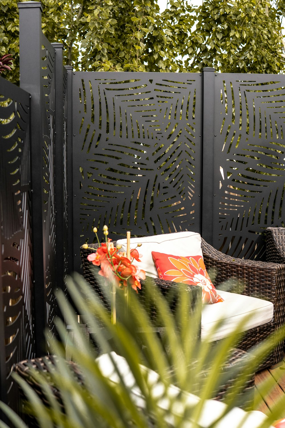 a patio with a chair and a table with flowers on it