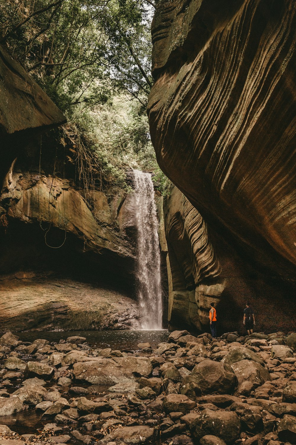 a man standing in front of a waterfall