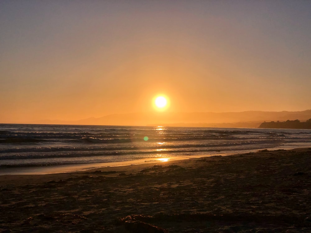 Die Sonne geht über dem Meer am Strand unter