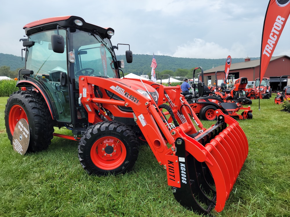 a red tractor parked on top of a lush green field