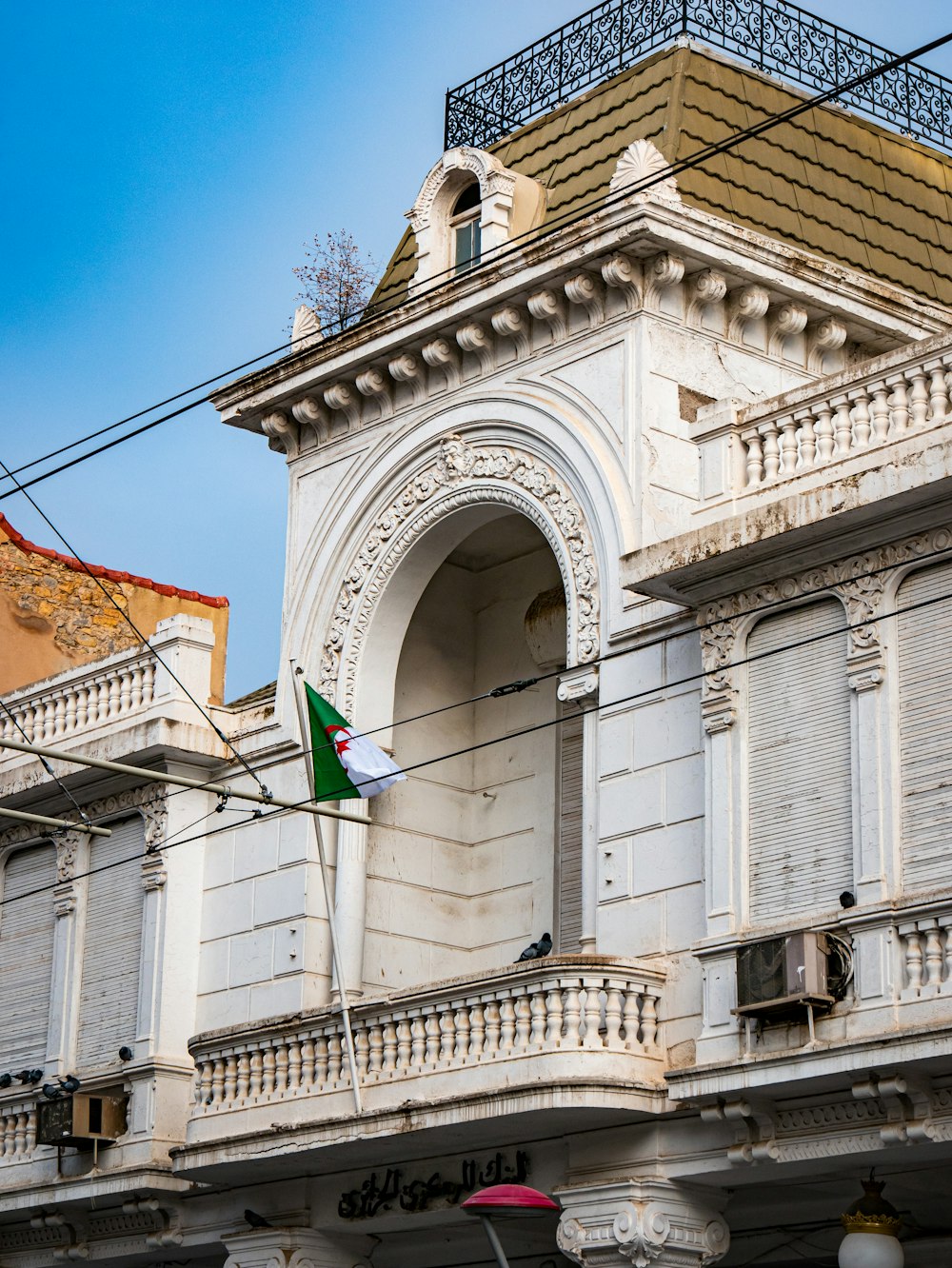 a white building with a green and white flag