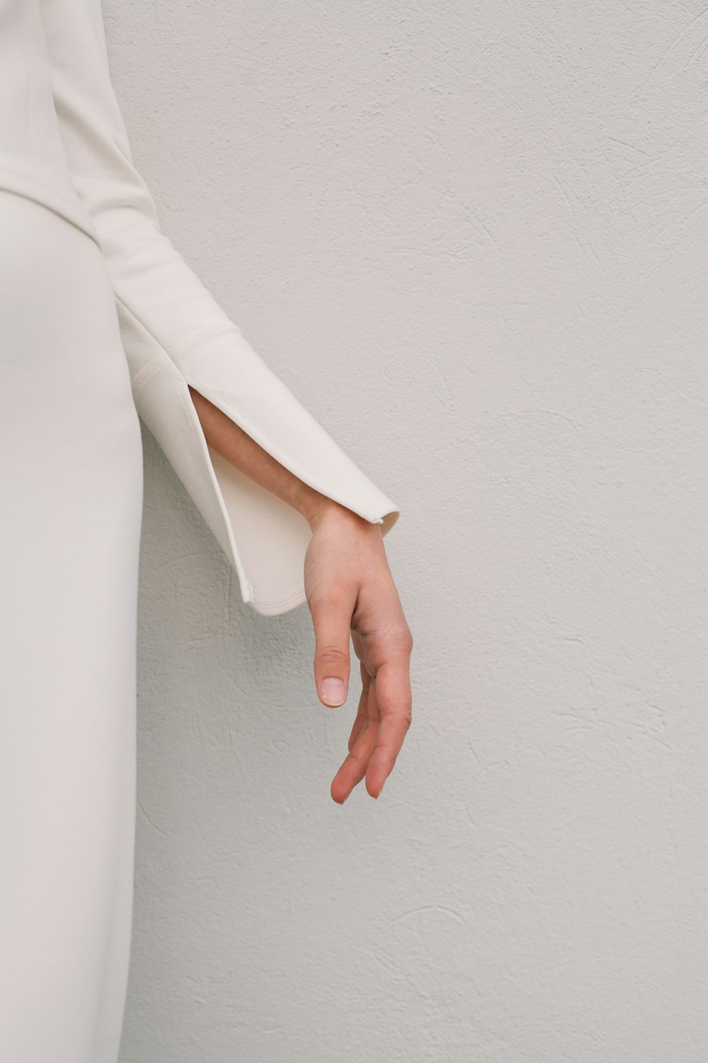 a woman in a white dress is holding her hand out