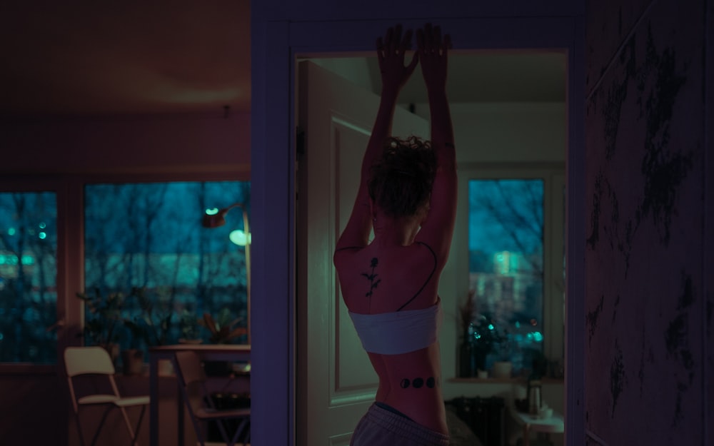 a woman in a bra top standing in front of a door