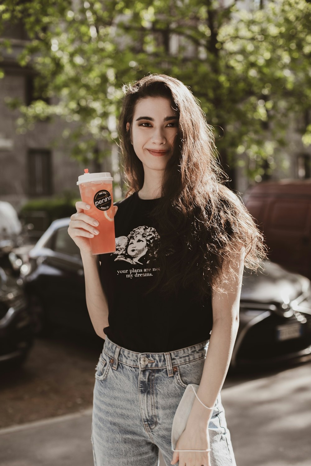 a woman holding a drink and a cell phone