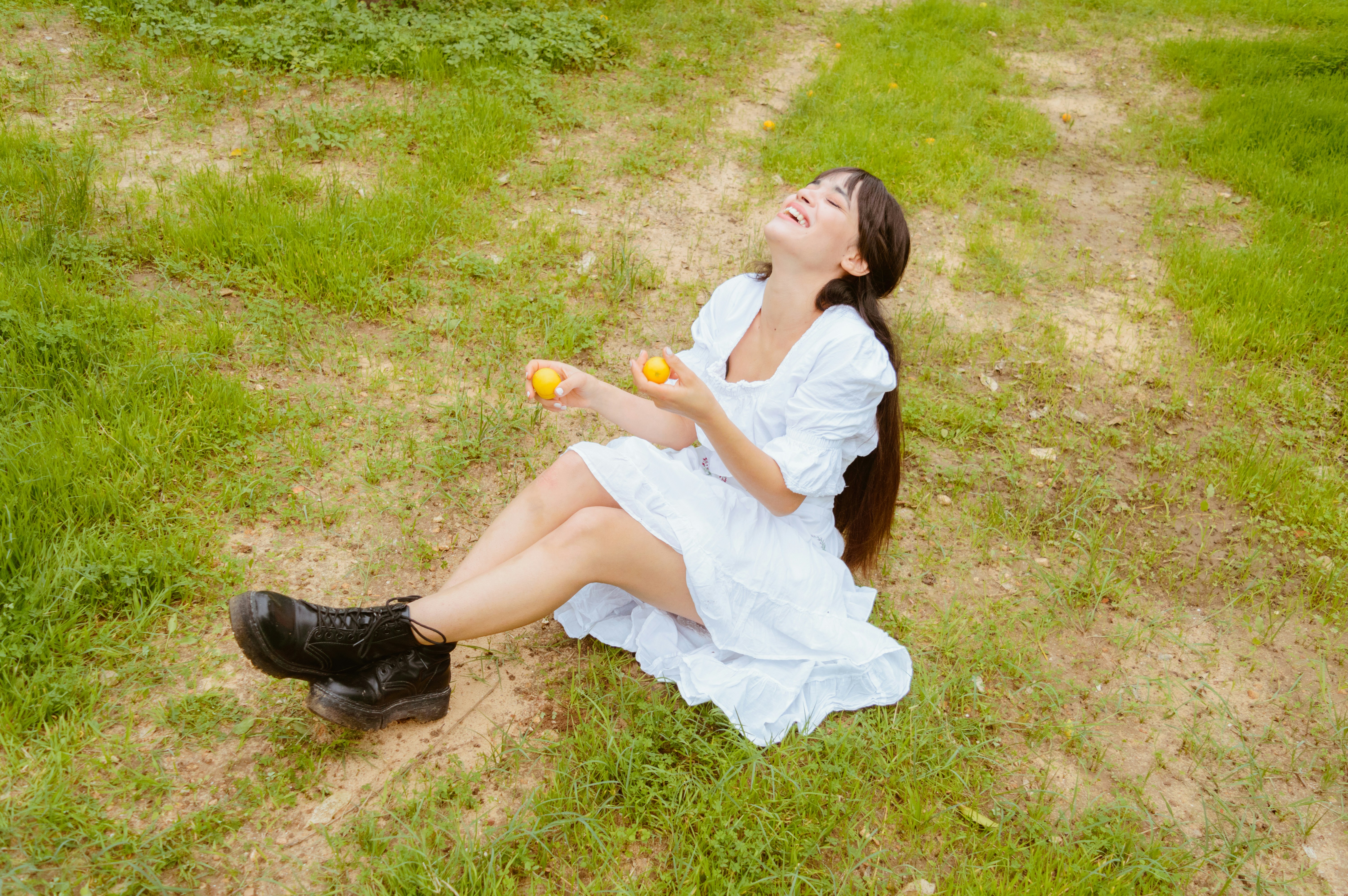 A woman in a white dress sitting on the ground photo – Free Woman Image ...