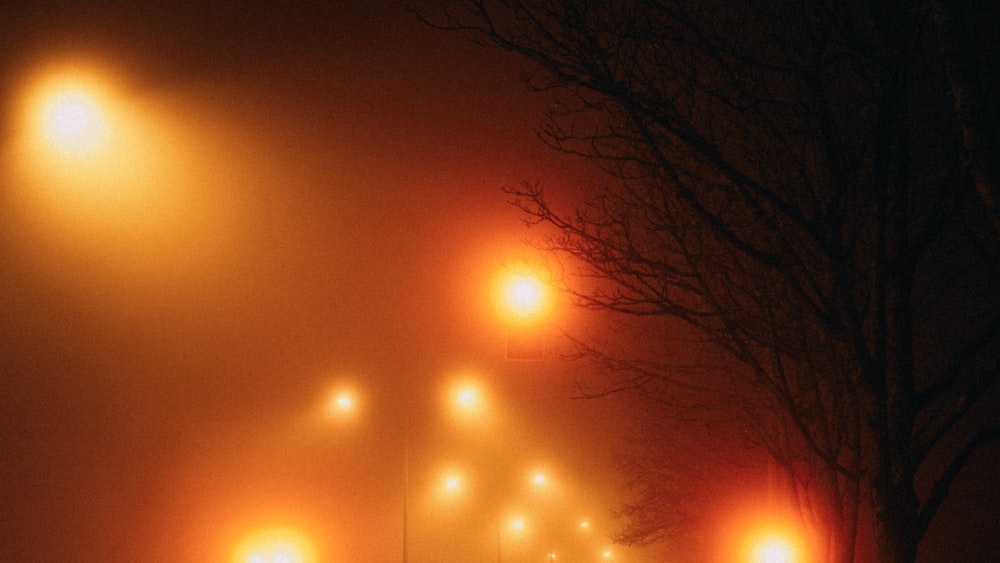 Una calle con niebla por la noche con luces de la calle