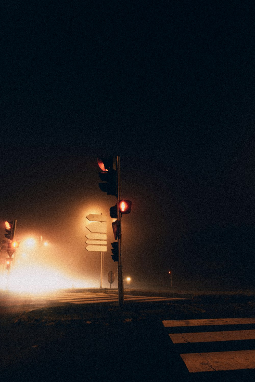 a foggy night with traffic lights and street signs