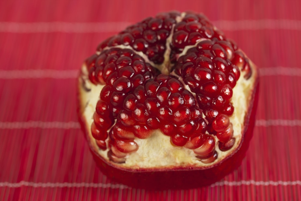 a pomegranate on a red table cloth