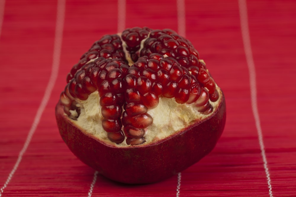 a pomegranate on a red table cloth