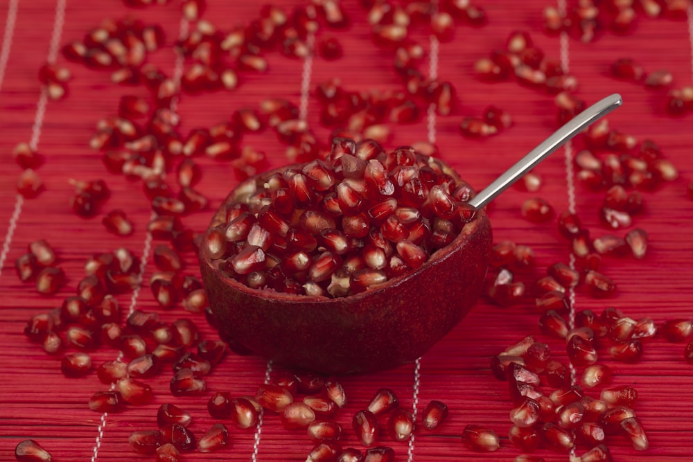 a wooden bowl filled with pomegranate on top of a table