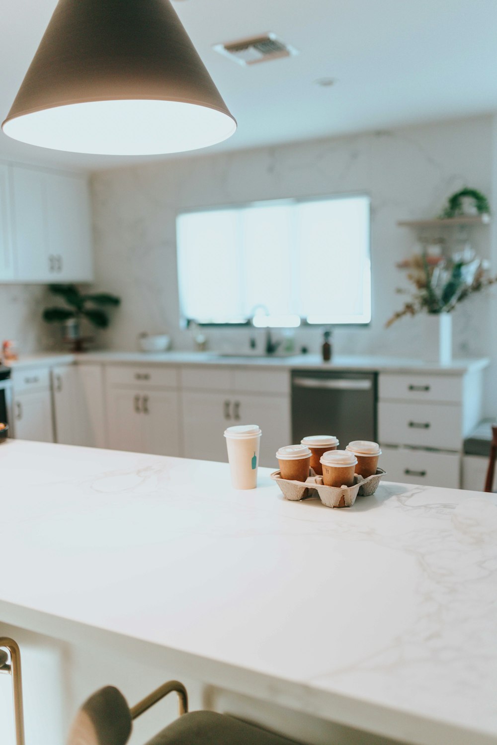 a kitchen with a white counter top and a light hanging over it