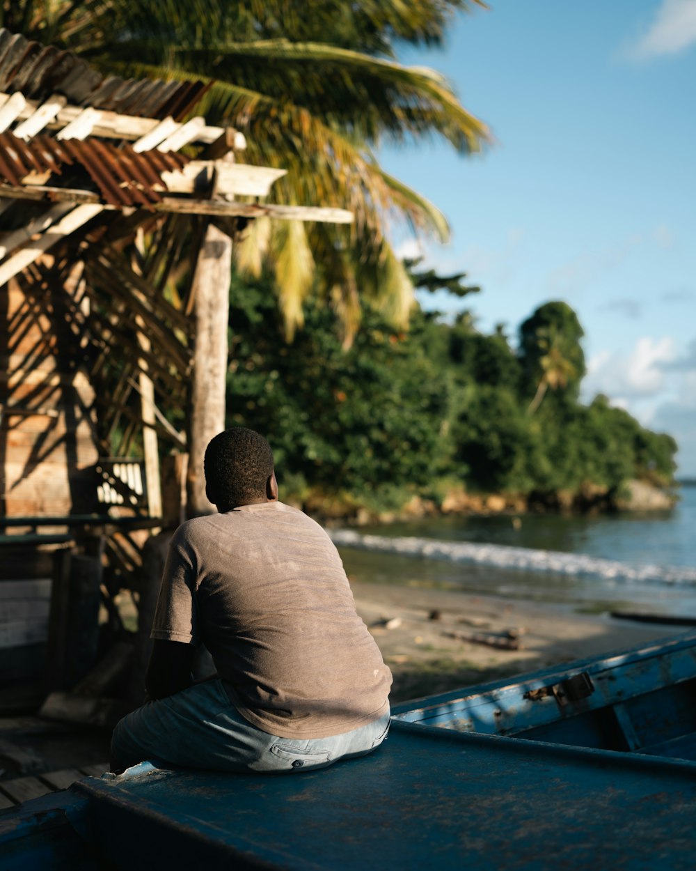 a man sitting on the back of a blue boat