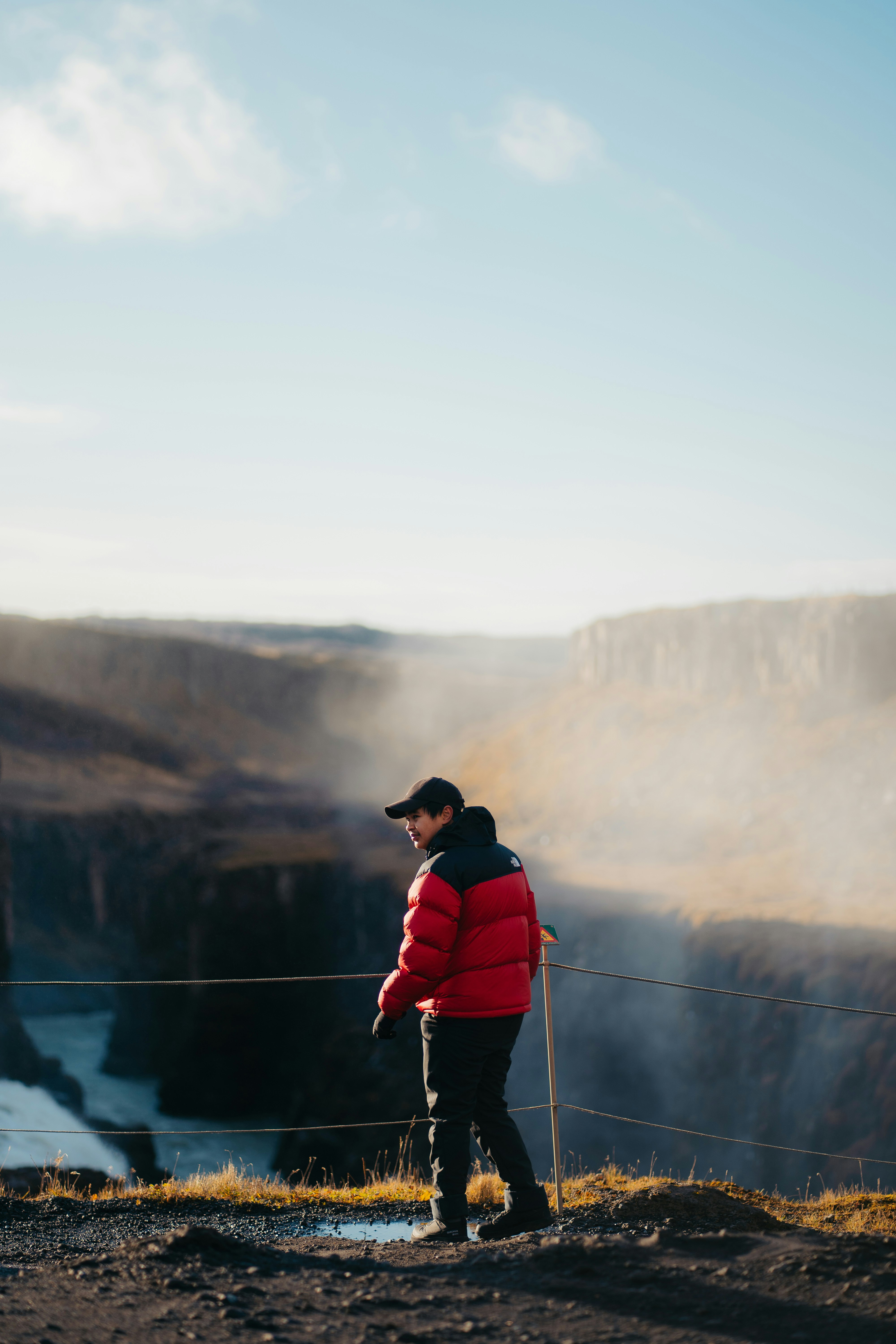 a man in a red jacket standing on top of a hill