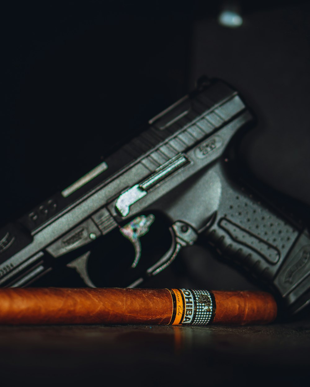 a cigar sitting next to a gun on a table