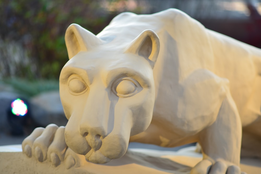 a white statue of a cat on a ledge