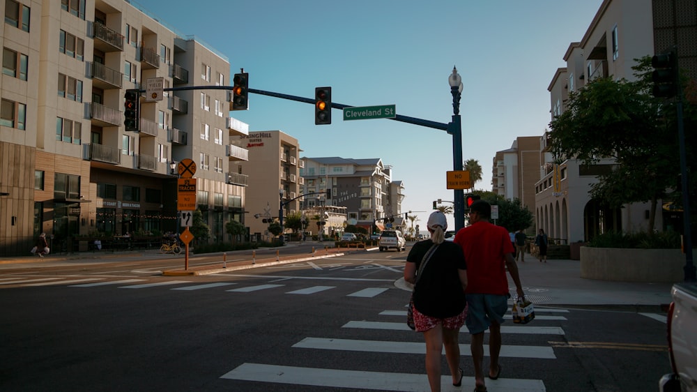 a couple of people that are walking across a street