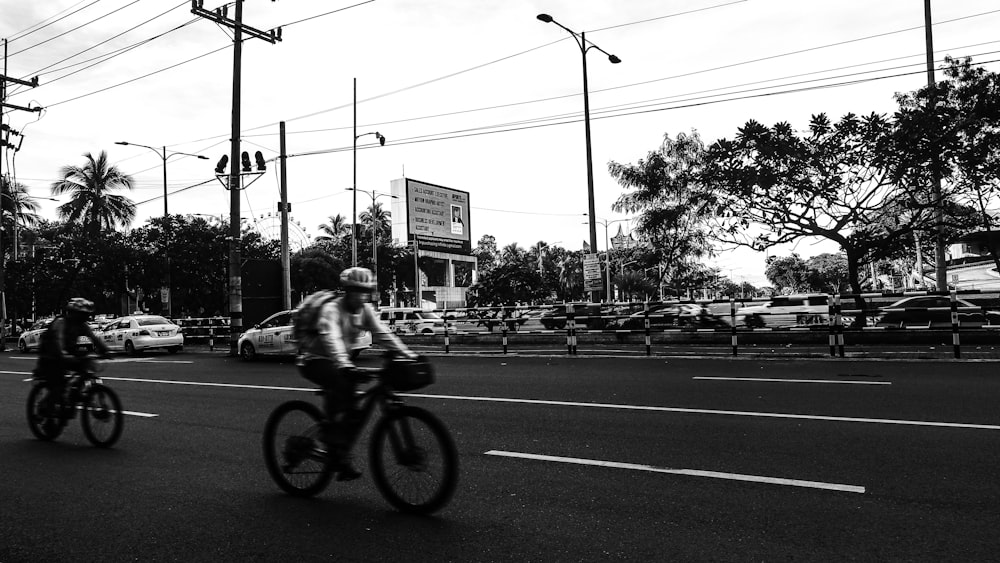 a couple of people riding bikes down a street