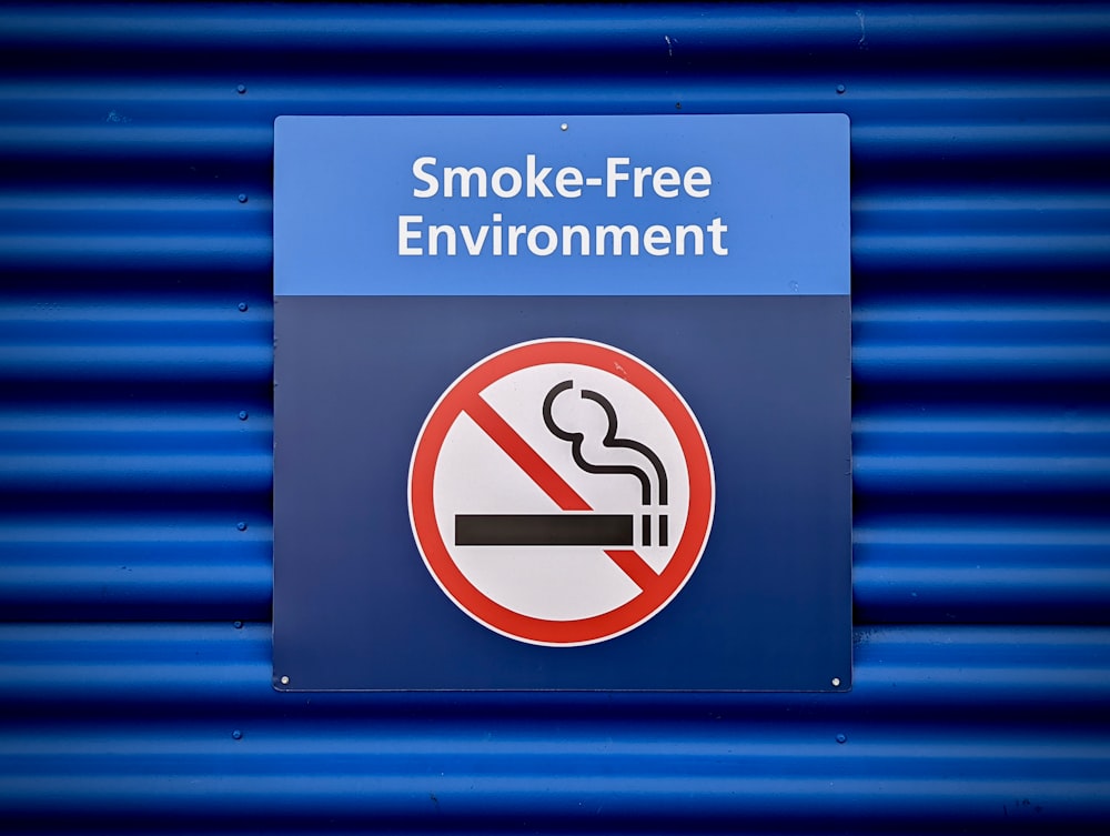 un cartello blu con un cartello di divieto di fumo su di esso