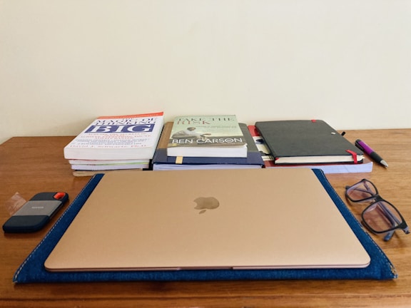 Books and stationery arranged neatly on a wooden desk.