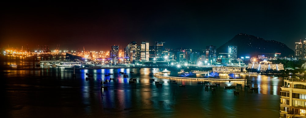 a city skyline at night with lights reflecting off the water