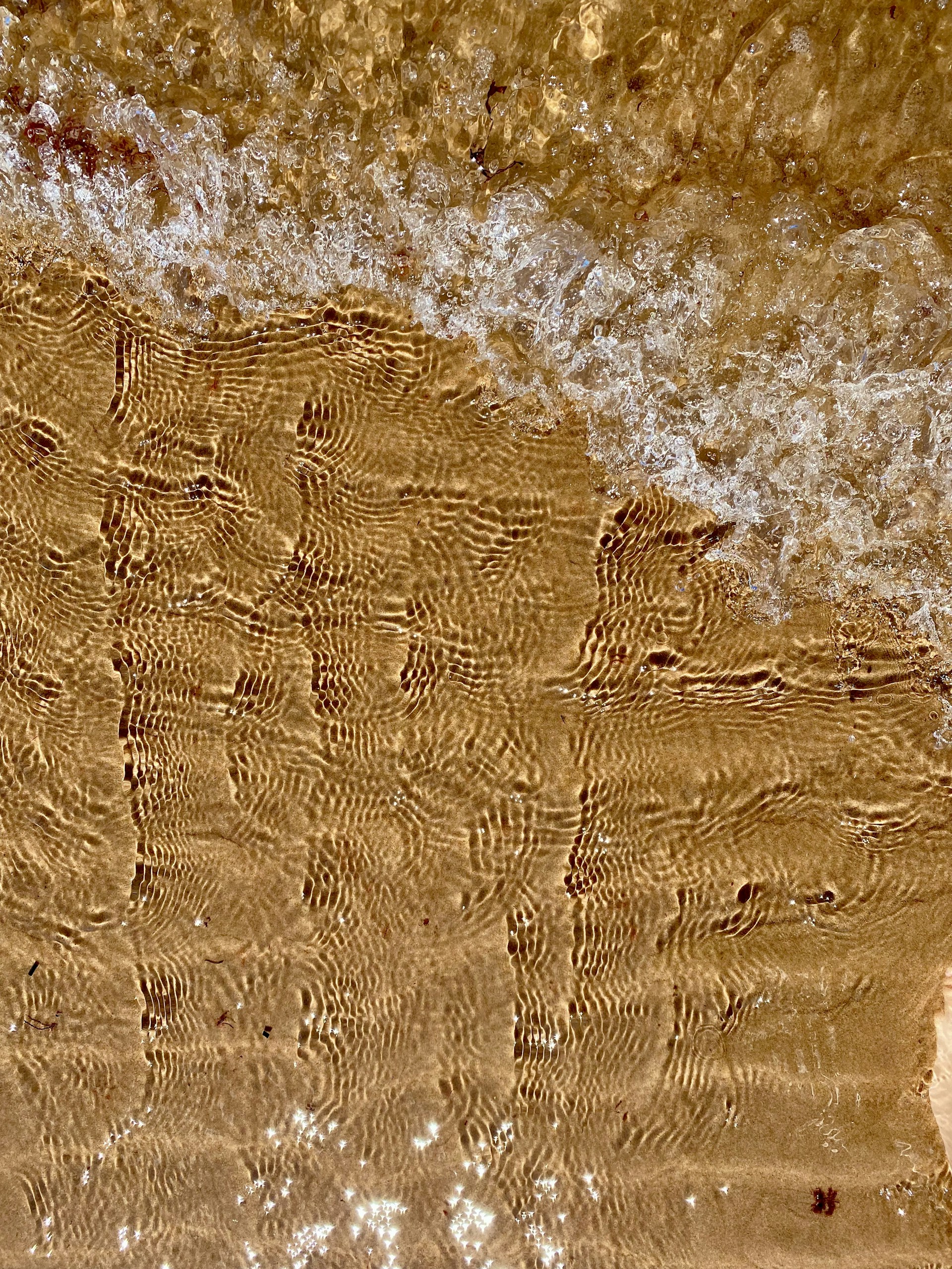 a close up of water and sand on a beach