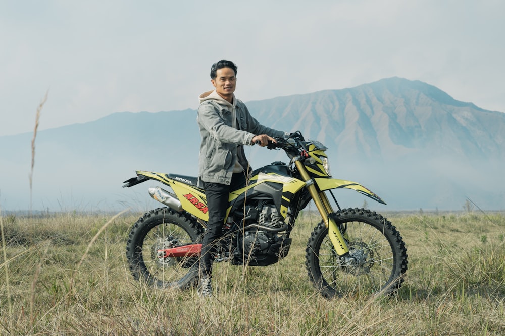 a man standing next to a yellow dirt bike