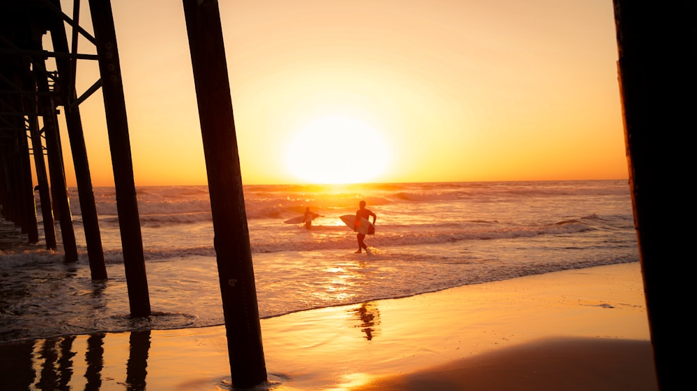 a person holding a surfboard walking into the ocean