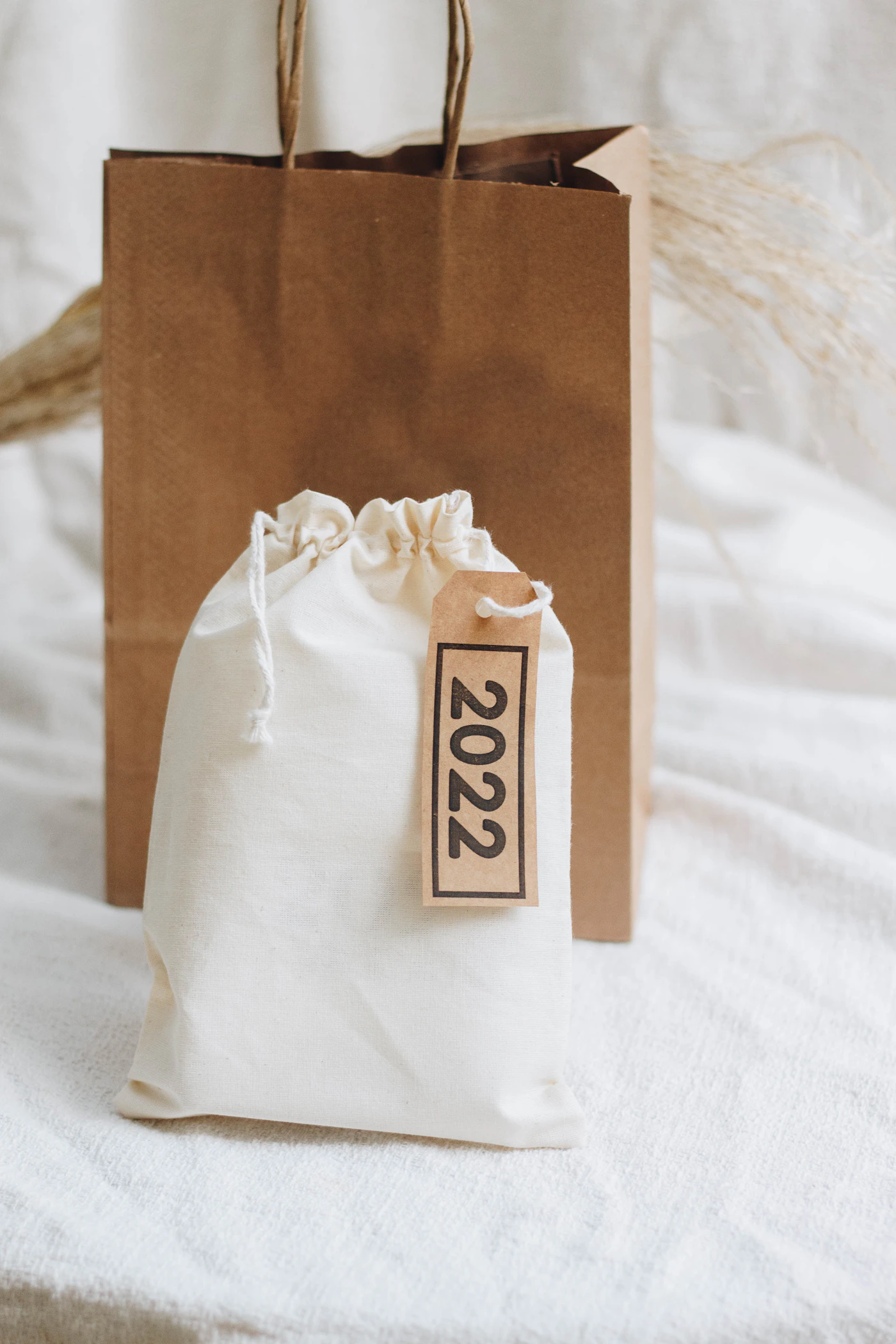 How to assemble DIY welcome bags for guests — Hands assembling wedding welcome bags on a long table using the assembly-line method