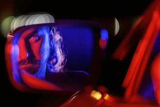 a reflection of a man in a car mirror