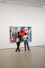 Close-up of a visitor admiring a vibrant abstract painting in the gallery.