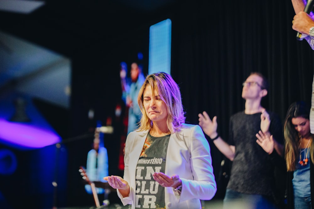 a woman standing in front of a microphone and clapping