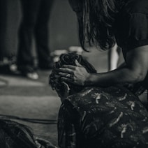 a woman sitting on the floor holding a cat