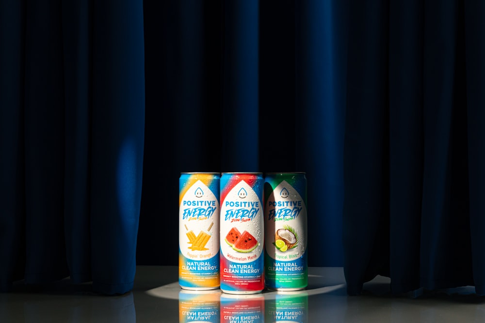a group of three cans of fruit juice