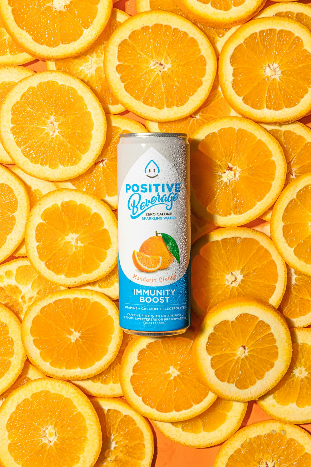 a can of orange juice surrounded by orange slices