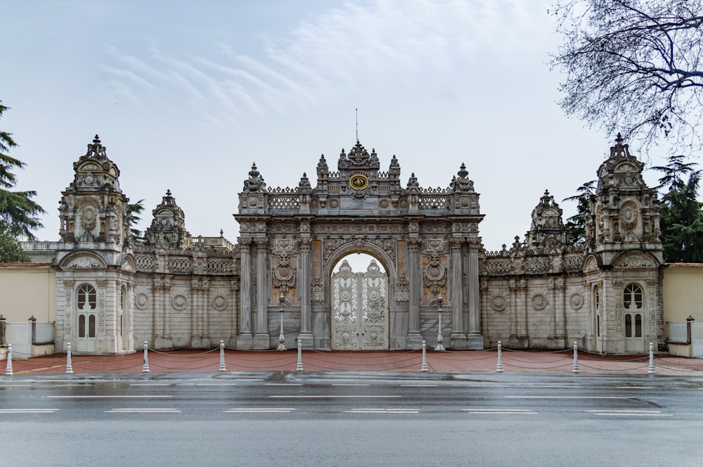 a large gate in front of a building with a clock on it