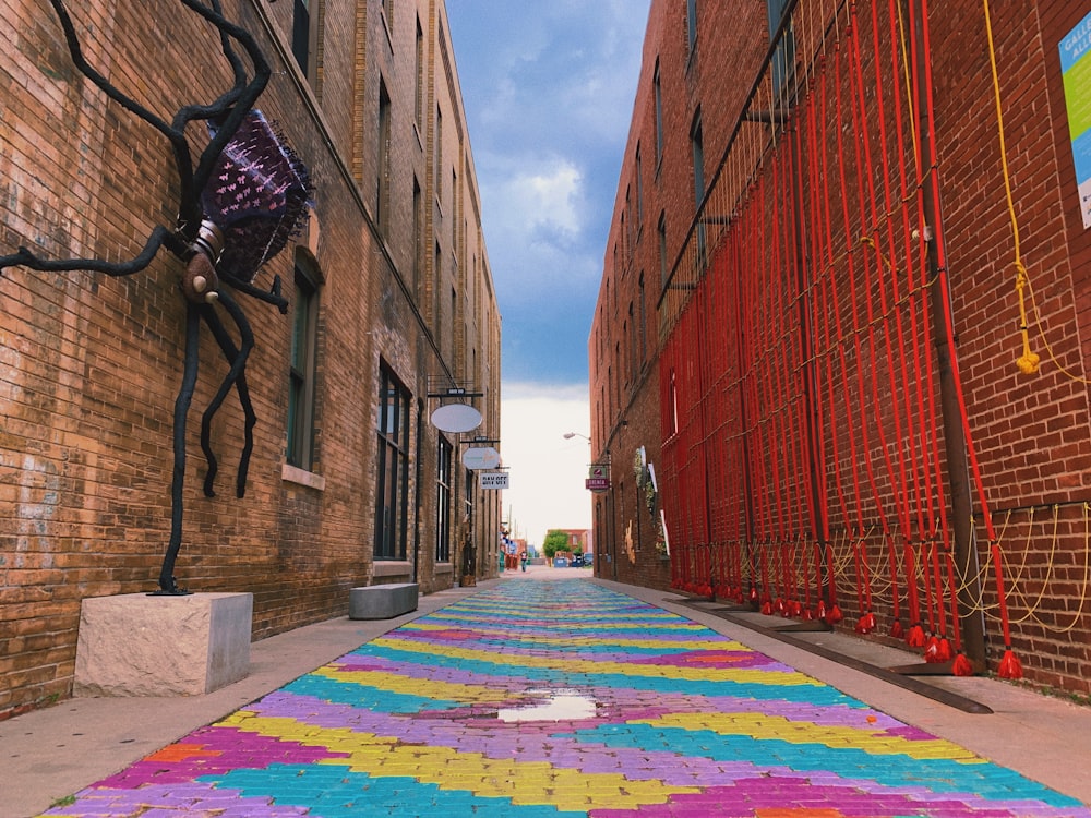 una calle con una alfombra de colores en el costado de la misma