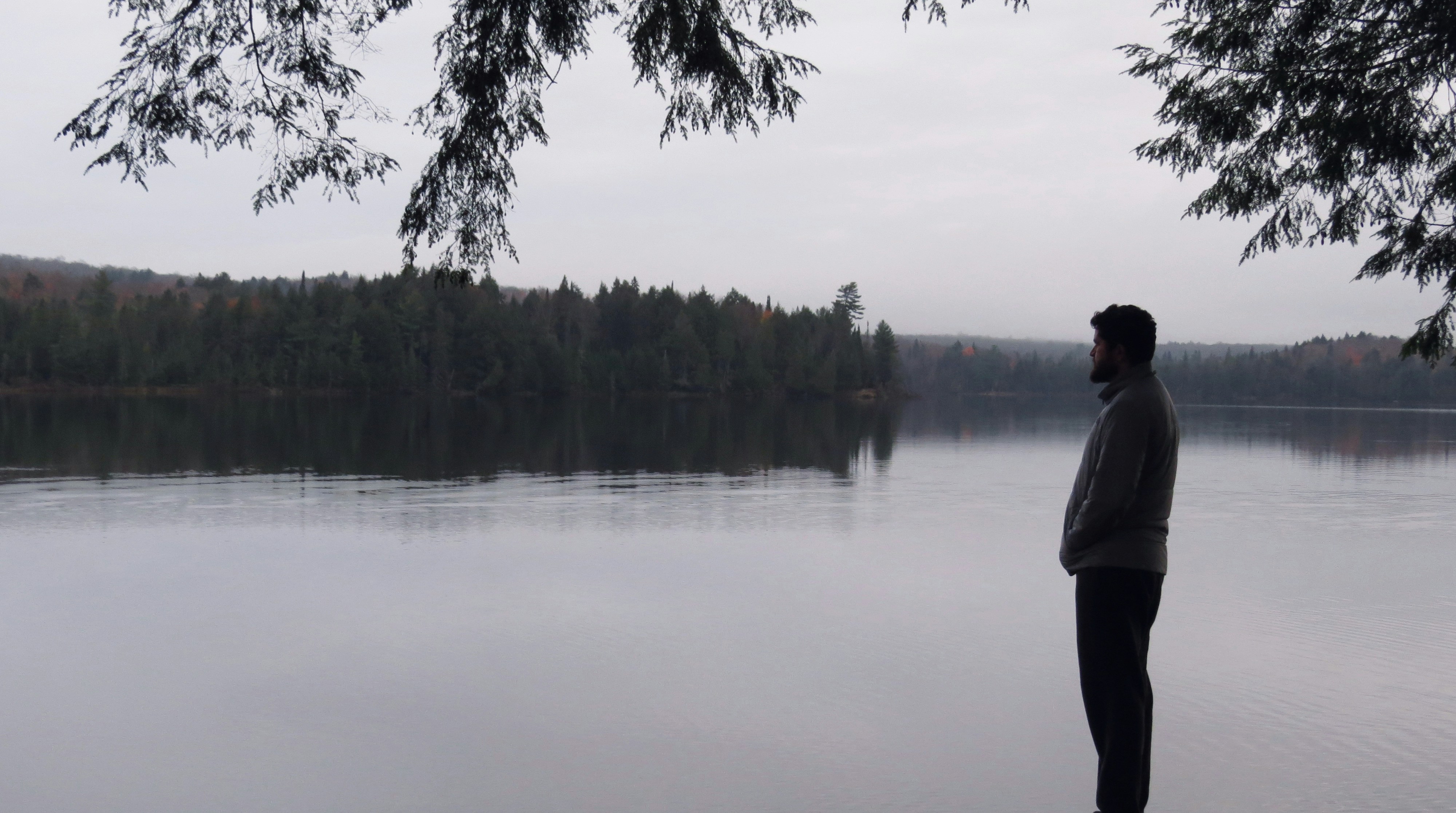 a man standing in front of a body of water