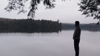 a man standing in front of a body of water