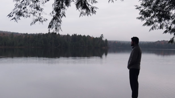 a man standing in front of a body of water