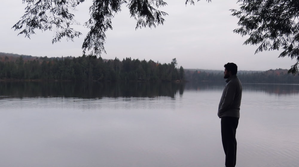 a man standing in front of a body of water