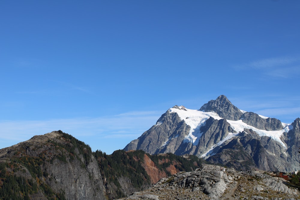 a mountain range with snow capped mountains in the background