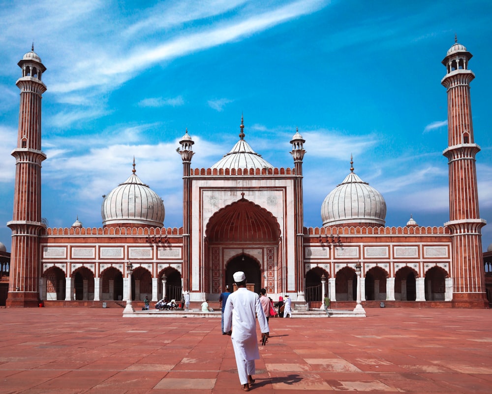 a man walking in front of a large building