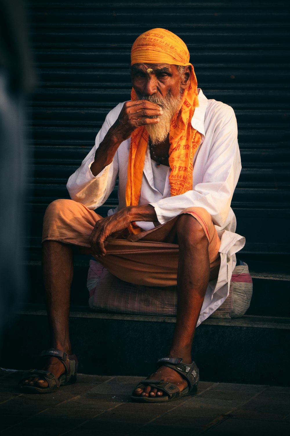um homem com um turbante amarelo sentado em um degrau