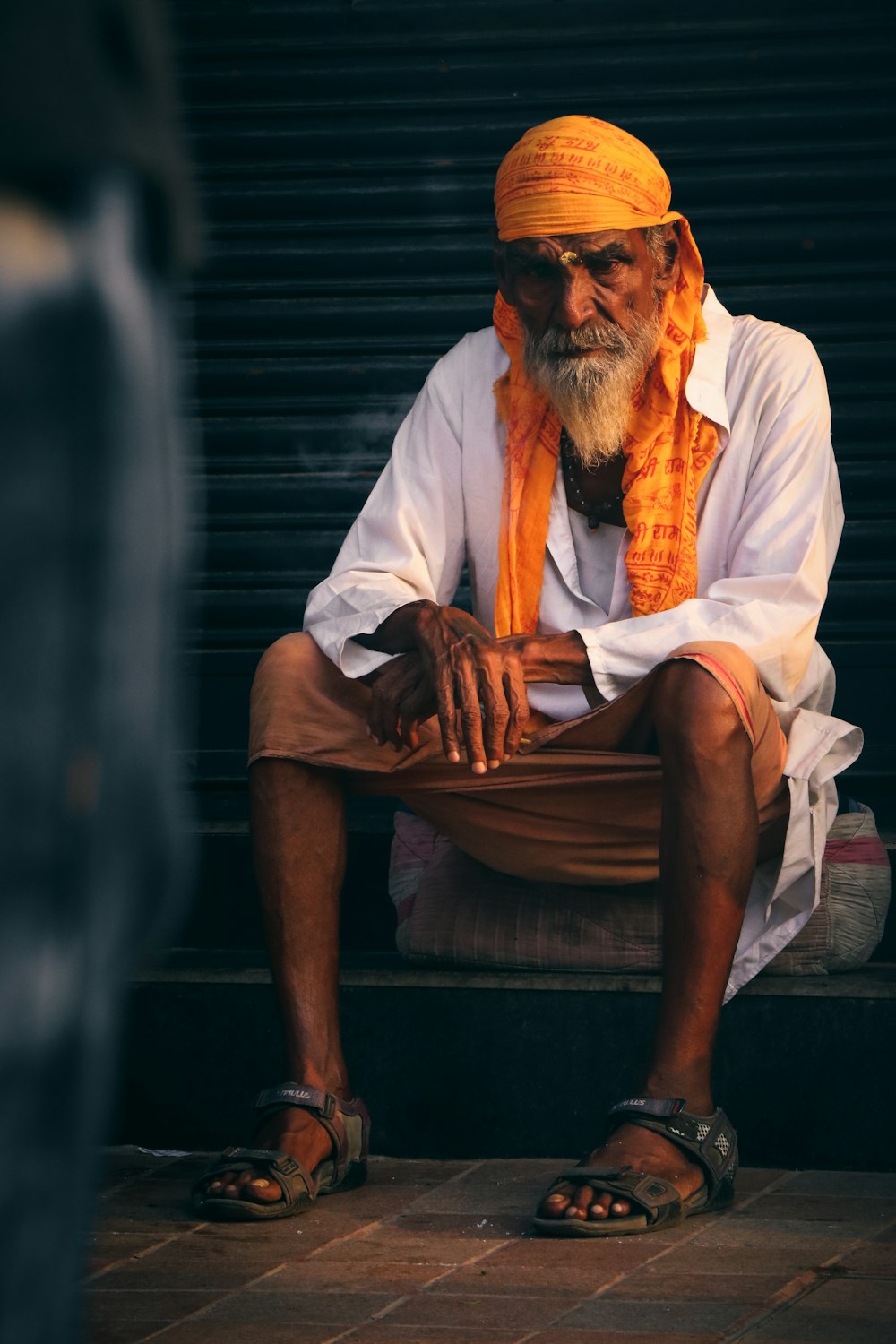 um homem com um turbante amarelo sentado em um banco