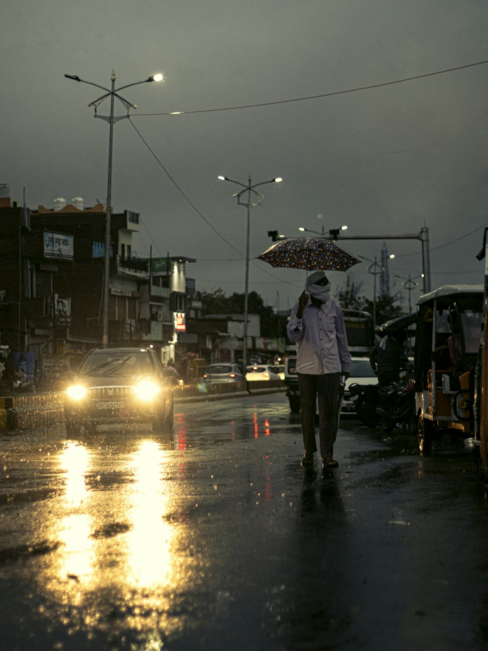 a woman walking down a street holding an umbrella