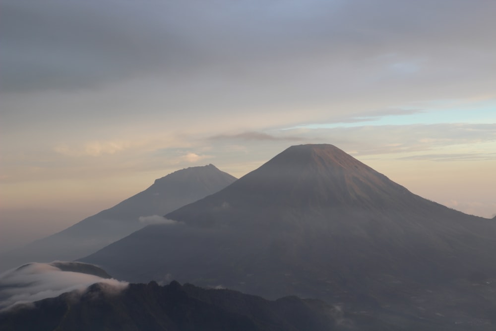 a view of a mountain with clouds in the foreground